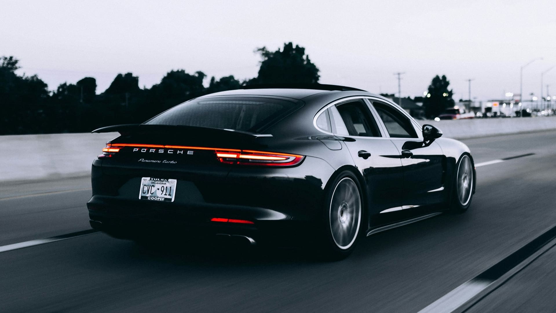 A black Porsche Panamera Turbo on the highway at dusk